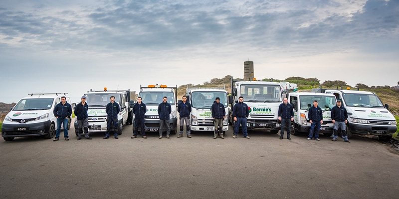 Bernie's Gardening Services team photo with the branded vehicles.