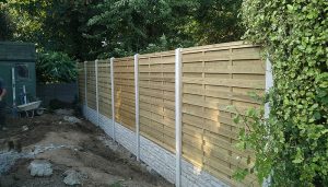 Quality garden fence with concrete posts and a stone effect boards at the bottom. Looks modern and clean.