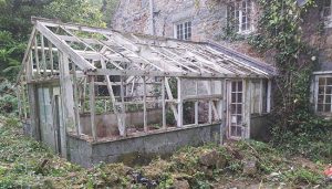 An old broken greenhouse in Guernsey attached to back of house.